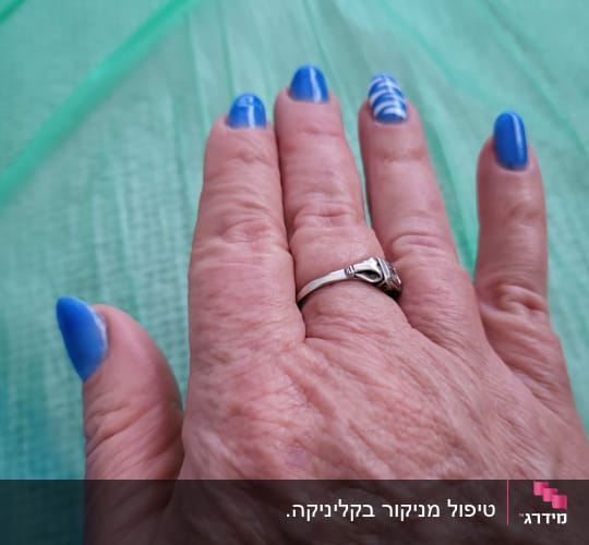 יד עם ציפורניים כחולות מעוצבות